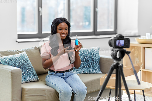 Image of female beauty blogger with camera and cosmetics