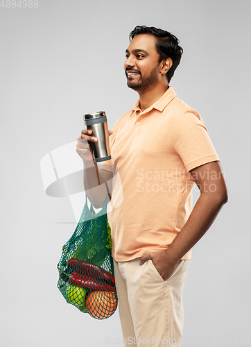 Image of man with food in bag and tumbler or thermo cup