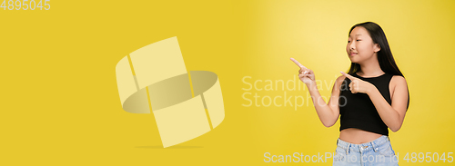 Image of Portrait of young asian girl isolated on yellow studio background