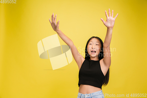 Image of Portrait of young asian girl isolated on yellow studio background