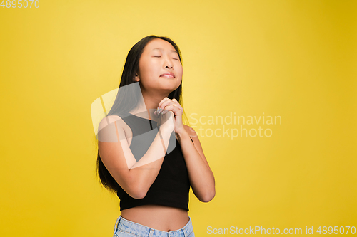 Image of Portrait of young asian girl isolated on yellow studio background