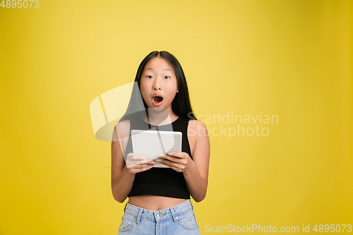 Image of Portrait of young asian girl isolated on yellow studio background