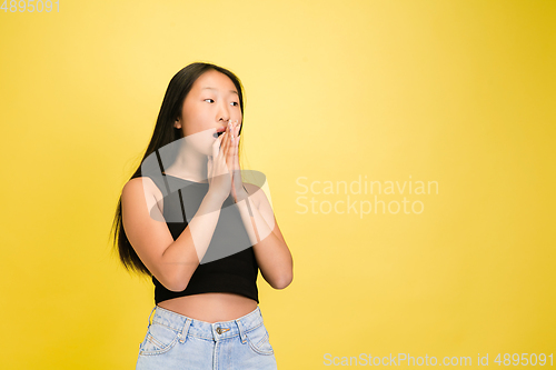 Image of Portrait of young asian girl isolated on yellow studio background