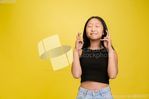 Image of Portrait of young asian girl isolated on yellow studio background