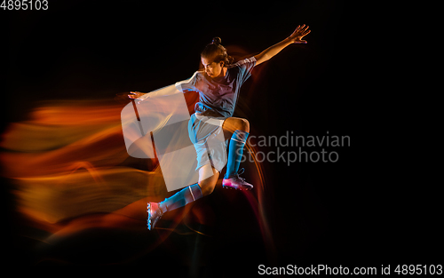 Image of Football or soccer player on black background in mixed light, fire shadows