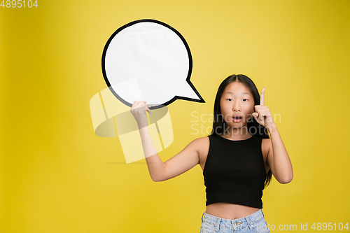 Image of Portrait of young asian girl isolated on yellow studio background