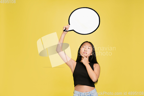 Image of Portrait of young asian girl isolated on yellow studio background