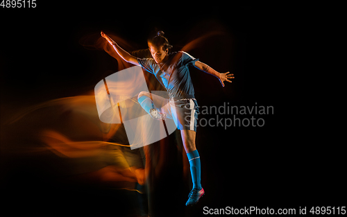 Image of Football or soccer player on black background in mixed light, fire shadows