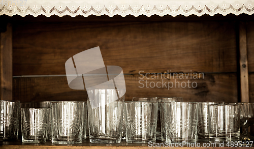 Image of glasses on the shelf of an old cabinet