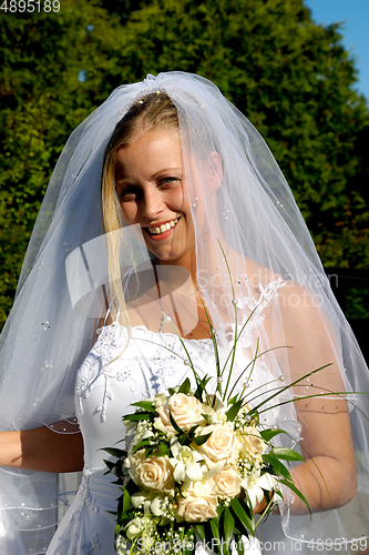 Image of Happy smiling wedding bride with bouquet.