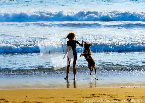 Image of Woman with dog at beach