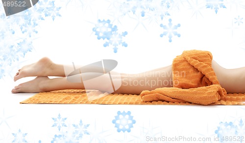 Image of legs of relaxed lady with orange towel