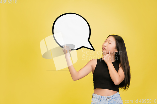 Image of Portrait of young asian girl isolated on yellow studio background