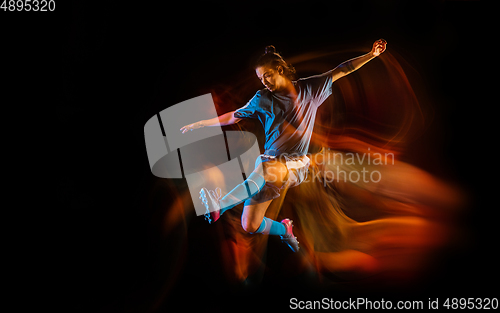 Image of Football or soccer player on black background in mixed light, fire shadows