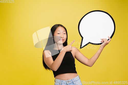 Image of Portrait of young asian girl isolated on yellow studio background