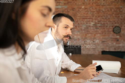 Image of Young family listening to male architect-engineer presents project of future house