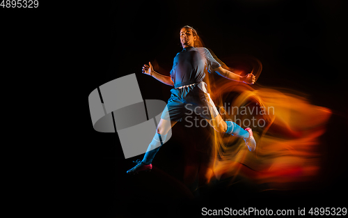 Image of Football or soccer player on black background in mixed light, fire shadows