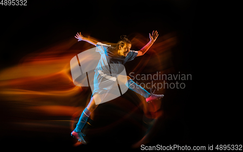 Image of Football or soccer player on black background in mixed light, fire shadows