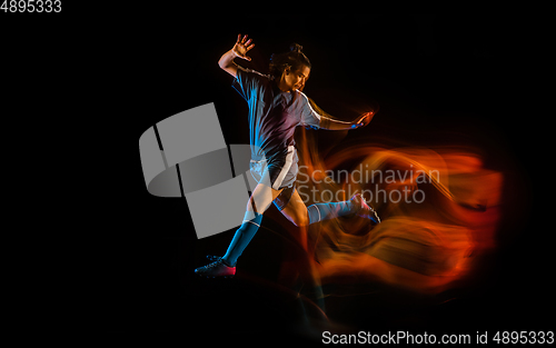 Image of Football or soccer player on black background in mixed light, fire shadows