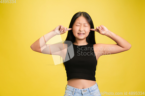 Image of Portrait of young asian girl isolated on yellow studio background