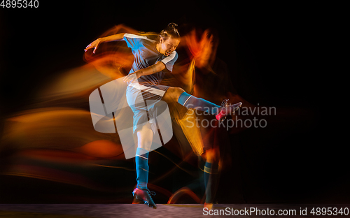Image of Football or soccer player on black background in mixed light, fire shadows