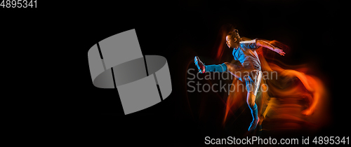 Image of Football or soccer player on black background in mixed light, fire shadows