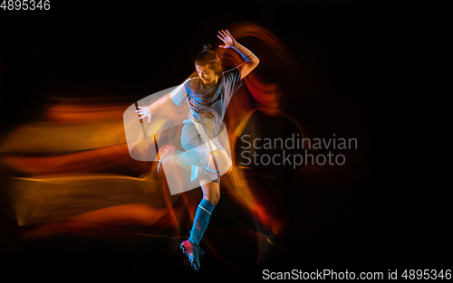 Image of Football or soccer player on black background in mixed light, fire shadows