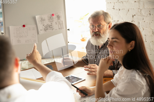 Image of Male architect-engineer presents project of future house for young family.