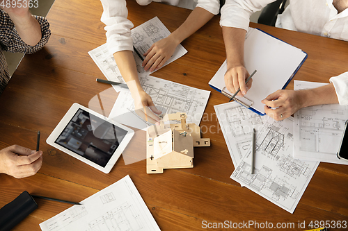 Image of Male architect-engineer presents project of future house for young family.