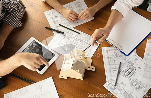 Image of Male architect-engineer presents project of future house for young family.