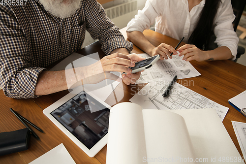 Image of Male architect-engineer presents project of future house for young family.