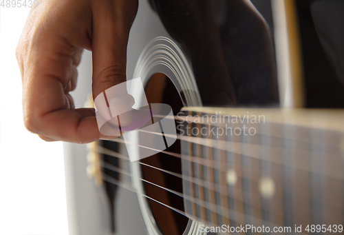 Image of Close up of guitarist hand playing guitar, copyspace, macro shot