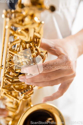 Image of Close up woman playing saxophone isolated on white studio background