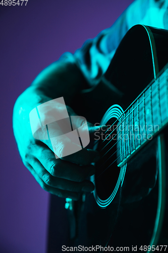 Image of Close up of guitarist hand playing guitar, copyspace, macro shot