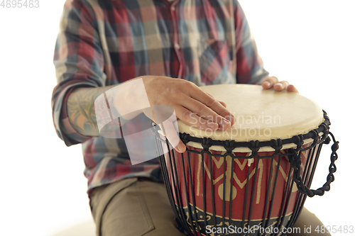 Image of Man plays ethnic drum darbuka percussion, close up musician isolated on white studio background