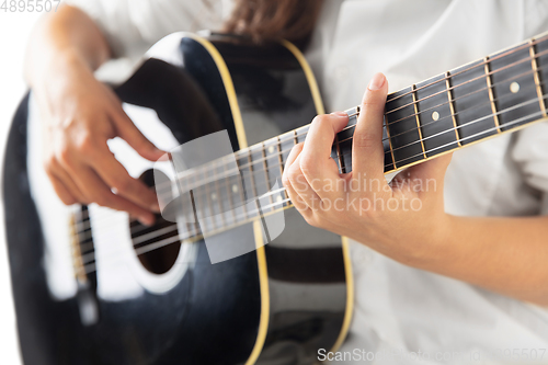 Image of Close up of guitarist hand playing guitar, copyspace, macro shot