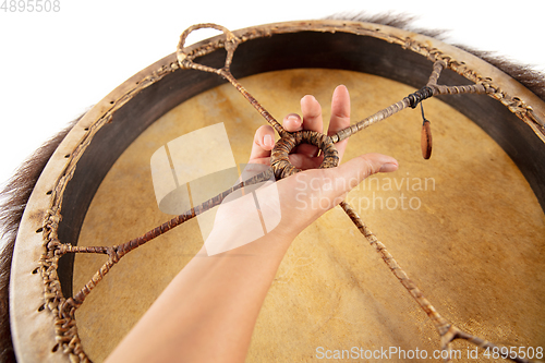 Image of A close up of hands playing the tambourine, percussion on white studio background