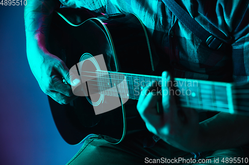 Image of Close up of guitarist hand playing guitar, copyspace, macro shot