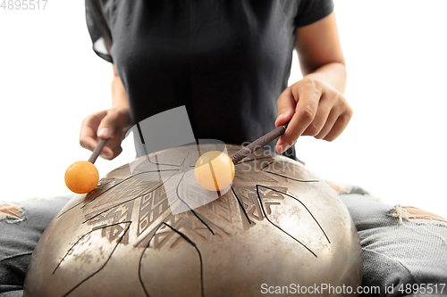 Image of A close up of hands playing the hank drum on white studio background