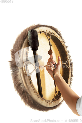 Image of A close up of hands playing the tambourine, percussion on white studio background