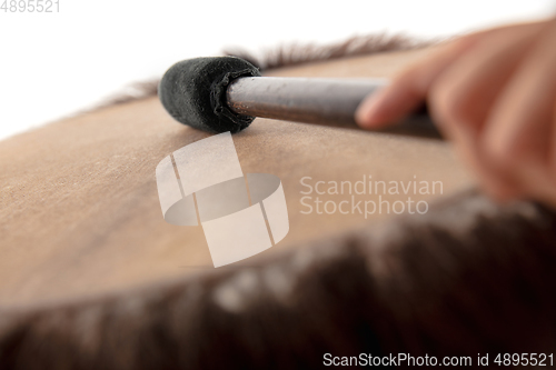 Image of A close up of hands playing the tambourine, percussion on white studio background