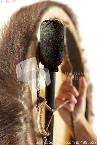 Image of A close up of hands playing the tambourine, percussion on white studio background