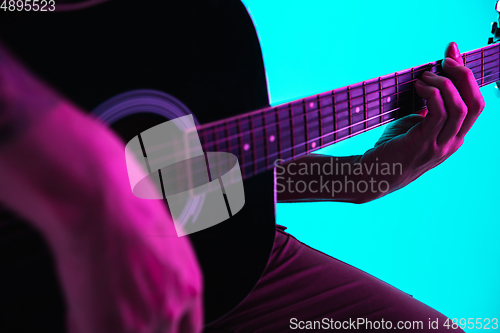 Image of Close up of guitarist hand playing guitar, copyspace, macro shot