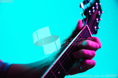 Image of Close up of guitarist hand playing guitar, copyspace, macro shot