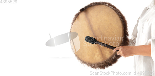 Image of A close up of hands playing the tambourine, percussion on white studio background