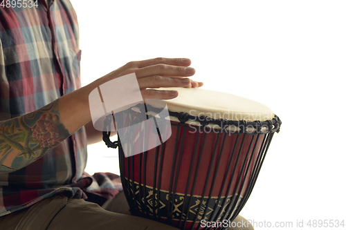 Image of Man plays ethnic drum darbuka percussion, close up musician isolated on white studio background