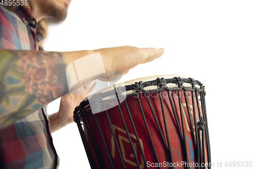 Image of Man plays ethnic drum darbuka percussion, close up musician isolated on white studio background