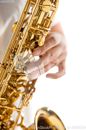 Image of Close up woman playing saxophone isolated on white studio background