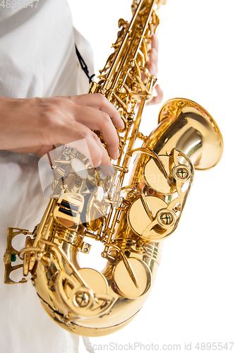 Image of Close up woman playing saxophone isolated on white studio background