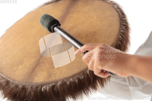 Image of A close up of hands playing the tambourine, percussion on white studio background